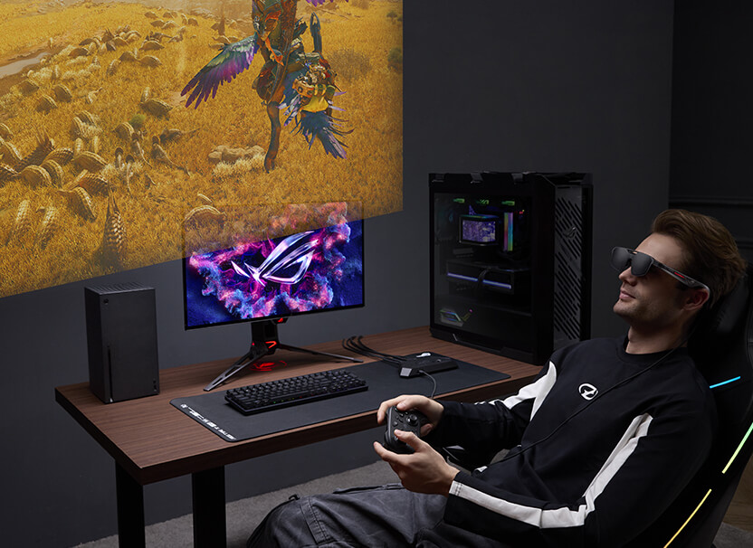 一名男子悠閒地坐在沙發上，配戴 ROG R1 電競 AR 眼鏡並使用 ROG Xbox Ally遊玩《魔物獵人》遊戲。